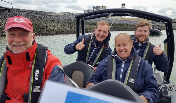 Participants donnant le pouce en l'air à bord d'un bateau au port