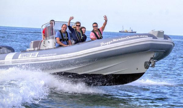 Bateau semi-rigide à pleine vitesse avec passagers souriants