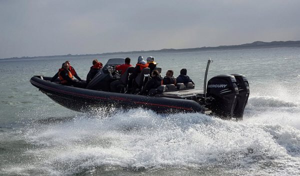 Powerboat chargé de passagers fendant les vagues en mer