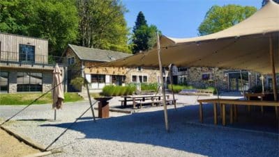Terrasse extérieure aménagée sous une grande tente près du bâtiment