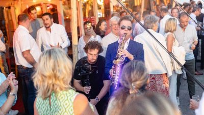 Musicien jouant du saxophone parmi les invités lors d'une soirée