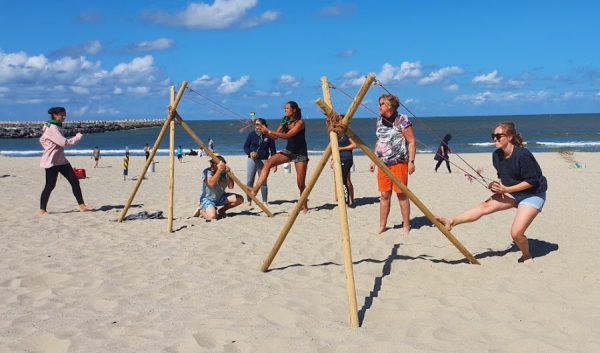 Groupe construisant une structure en bois lors d'un défi sur la plage