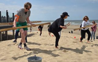005 Participant en équilibre sur une poutre lors d'un défi sur la plage