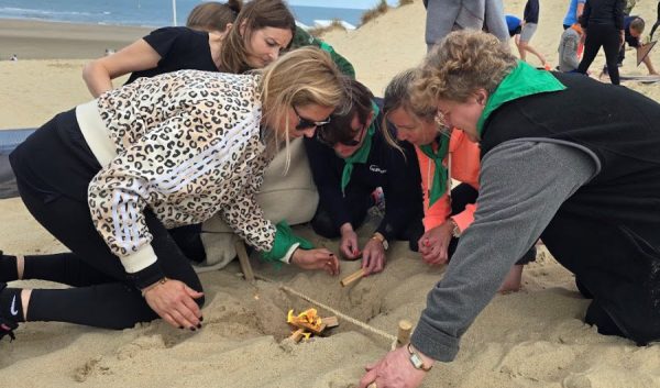 Groupe travaillant ensemble sur un défi dans le sable
