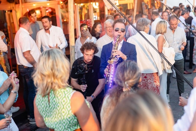 Saxophoniste au milieu des invités lors d’une soirée d’entreprise organisée par Xtreme Events