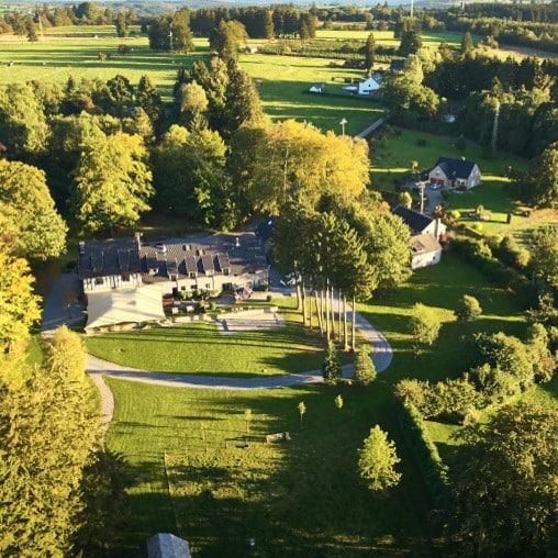 Vue aérienne du domaine de la Résidence Kottage en Ardenne, avec son étang et la forêt environnante