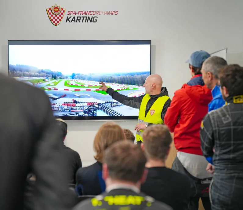 Briefing de sécurité devant le plan de la piste, présenté par un moniteur du karting