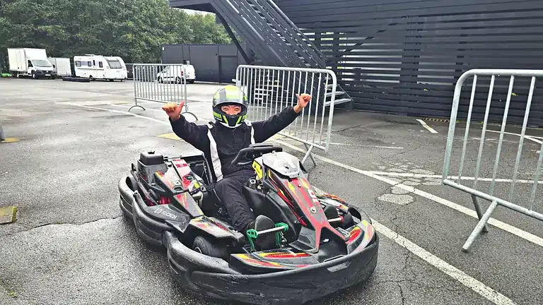 Pilote levant les deux pouces en rentrant au parc des karts