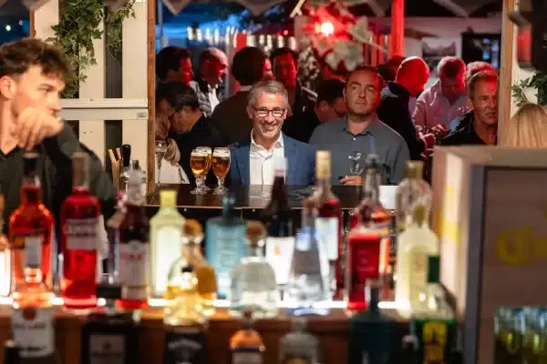Bar éclairé et invités lors d’une soirée au Knokke-Out Zoute