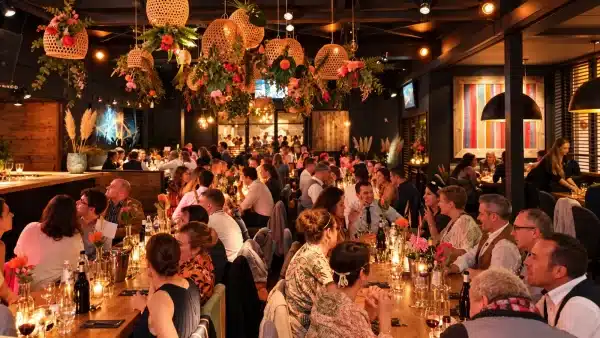 Dîner d’entreprise, tables dressées sous des suspensions fleuries
