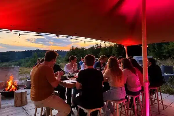 Dîner sous un abri éclairé, autour du feu, au coucher du soleil