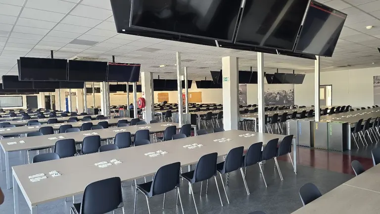 Espace de réception aménagé avec tables et écrans au Circuit de Spa-Francorchamps