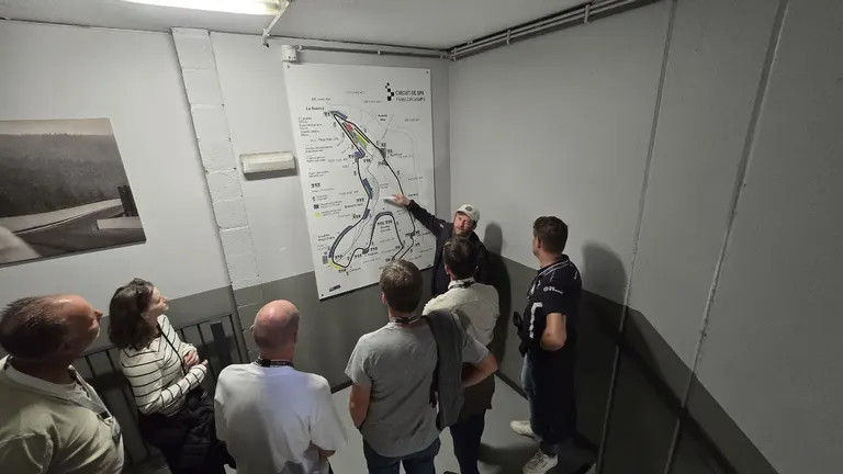 Guide présentant le plan du circuit à un groupe pendant la visite