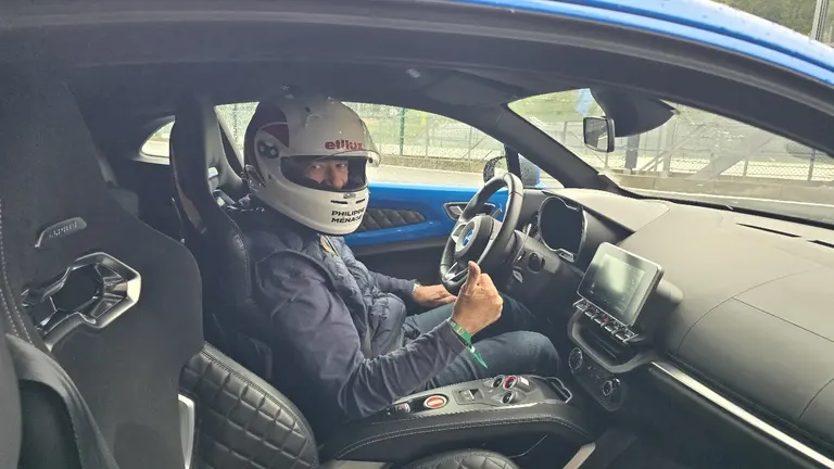 Participant casqué au volant d’une Alpine avant un tour de piste